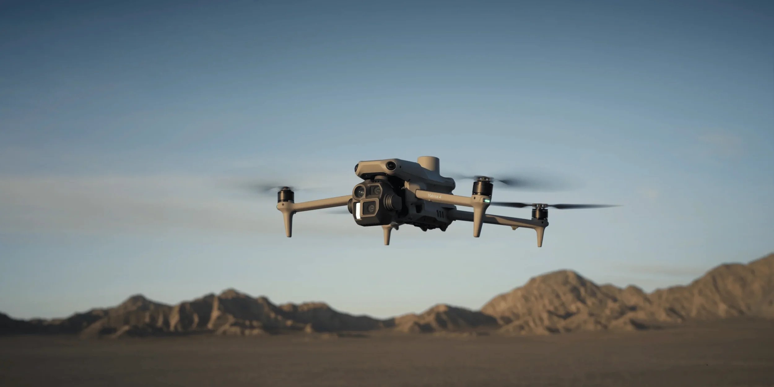 DJI Mavic 4 Enterprise drone flying over desert landscape.