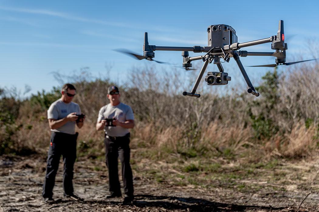 Drone crew operating a survey drone on an open field site.